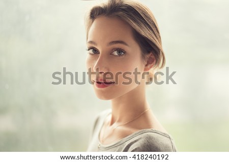 portrait of a beautiful girl on a background of a window
