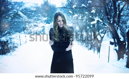 beautiful young woman freezes in the winter suburb