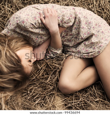 beautiful girl lying in the dry grass
