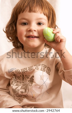 smiling cute girl holding Easter egg in her hand