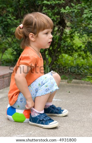little, cute girl with colorful football, outdoors