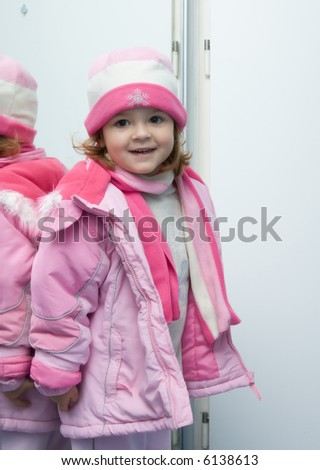 little, cute girl wearing pink winter clothes, soft focus