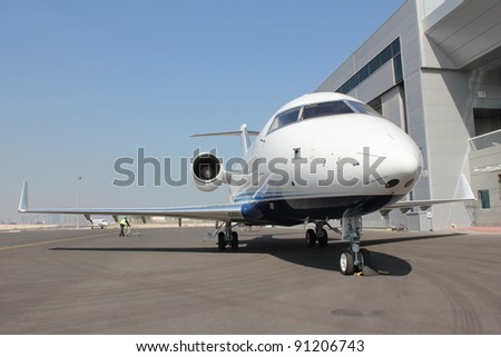Private jet parked outside hanger