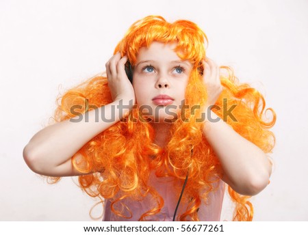 Beautiful little redheaded girl / child listening to disco music with headphones against white background
