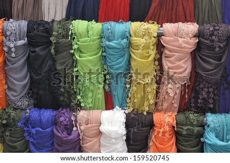 Many colored scarves on a display rack