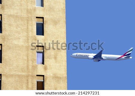 DUBAI, UNITED ARAB EMIRATES-FEBRUARY,10,2014;Airplane of Emirates Airline is taking off near apartment buildings in the city of Dubai. February 10,2014 Dubai