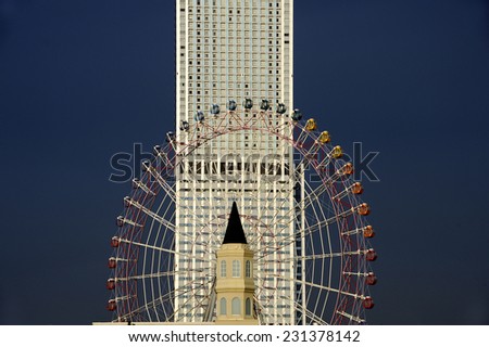 Sky scraper, tower and ferris wheel against dark blue sky. Near the bridge from Osaka International Airport to Osaka town