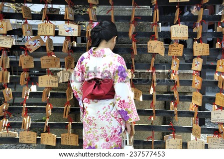 KYOTO, JAPAN-NOVEMBER 4, 2014; Geisha in front of prayer tablets at Rokuharamitsuji Temple. People write their wish on a wooden tablet (ema) November 4, 2014 Kyoto, Japan