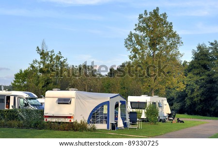 Camper and caravans at a camping at sunset. No brands, no numberplate and no people.