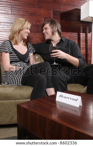 A man and woman talk in a wine lounge