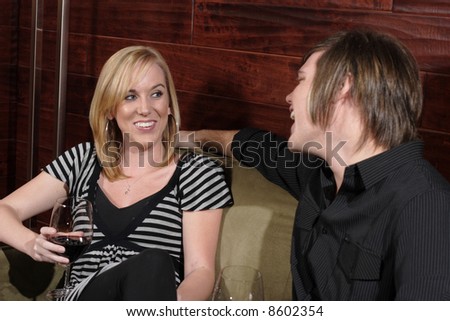 Man and Woman laugh during a conversation at a wine lounge