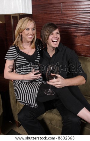 A man and woman laugh among friends at a wine lounge