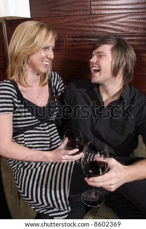 A man and a woman laugh at a wine lounge