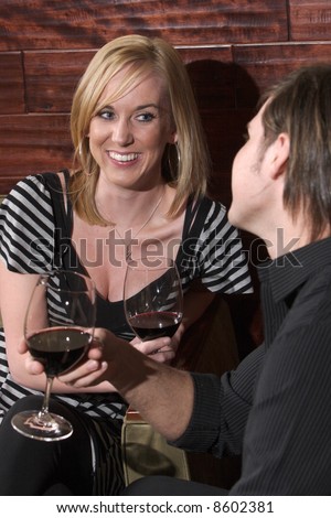 A man and a woman conversate in a wine lounge