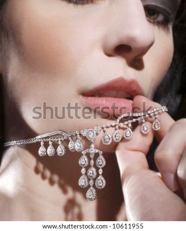 A sexy woman playing with her diamond necklace