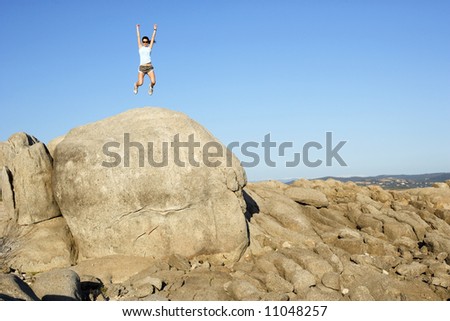 A woman jumps for joy when she reaches the top of the hill