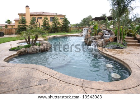 A Waterfall In To A Pool In A Luxury Backyard With Tropical ...