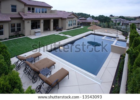 A Pool With A Waterfall In A Luxury Backyard With New Landscaping ...