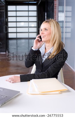 Business Woman on cell at desk in modern office