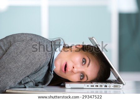 Stressed out business woman getting eaten by her work in a modern office