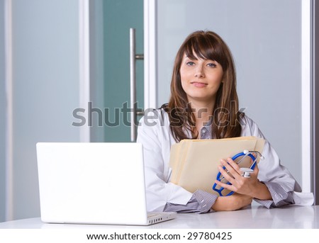 Woman doctor in a modern office at a desk with a laptop