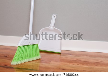 A broom and dust pan on New Hardwood Flooring