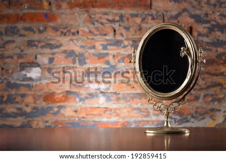 Golden vintage mirror on wood table
