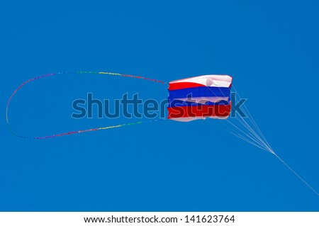 Colourful handbag kite against blue sky, red white and blue