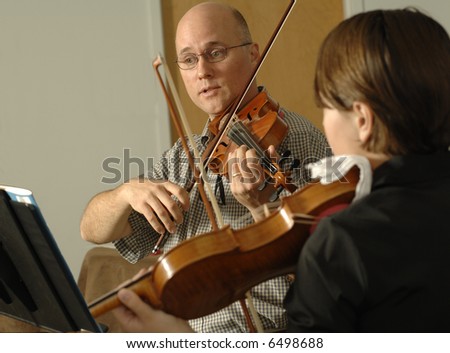 a teacher demonstrates at violin lessons