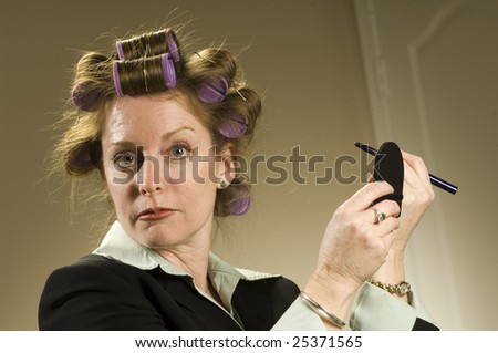 a woman in curlers puts on her makeup