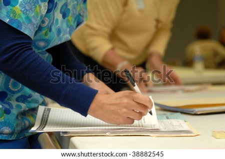 a nurse at work with papers at her station