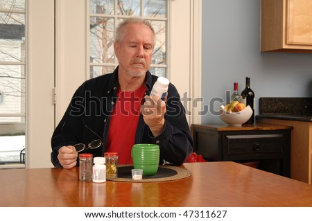 a man of retirement age reading the label of a vitamin bottle