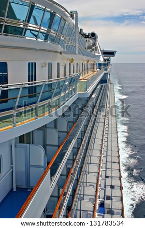 Port side of a large modern cruise ship showing balconies