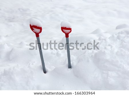 Kid\'s shovels left in the snow bank before a snowfall