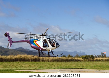 LIHUE, KAUAI, HAWAII - JANUARY 21, 2012: Jack Harter helicopters fly tourists around Kauai Island in Hawaii. This Hughes 500 flies with the doors off for a more thrilling experience.