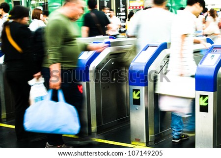 Busy city people walking in subway station in motion blur