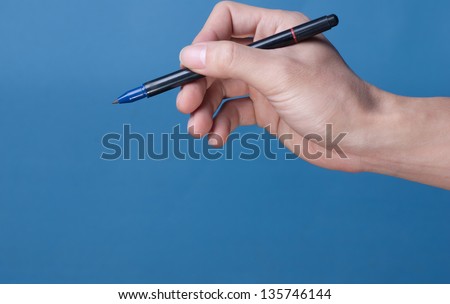 Hand with pen isolated on blue background
