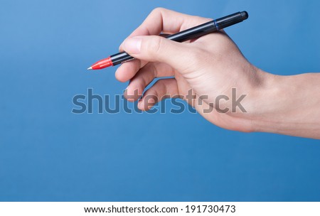 Hand with pen isolated on blue background