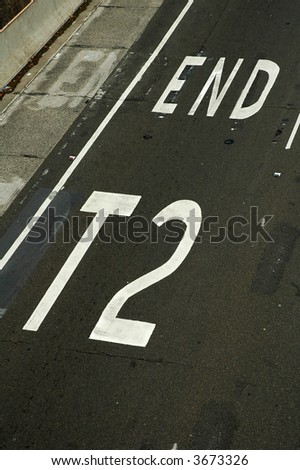 road and pavement detail, white line and text \'END T2\'