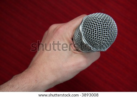 steel microphone in man hand, red background