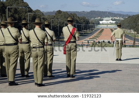 australian soldiers standing in front of australian war museum in Canberra, modern Parliament House in background, Anzac Parade