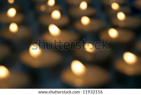 several burning candles, photo is out of focus, creating an soft effect