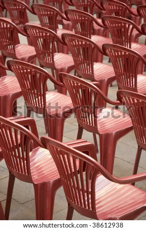 red plastic chairs prepared for an outdoor entertainment event, vertical photo