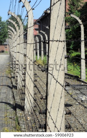 vertical photo of an old wired prison fence under electric current