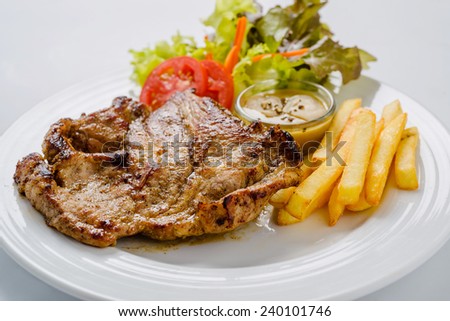 Pork steak with french fries and salad ready to serve.