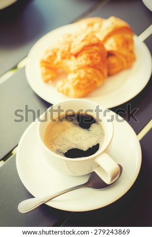 Croissant Breakfast served with black coffee and a breakfast menu, such as orange juice, jam, eggs, filling it.