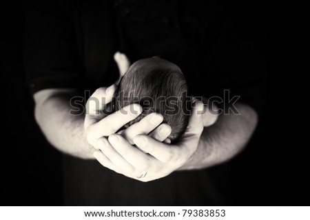 Newborn head in hands