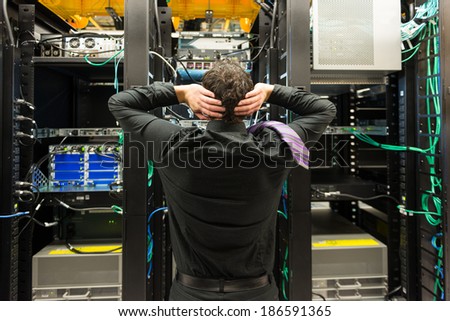 Trouble in data center. Man looking astonished in a network data center.