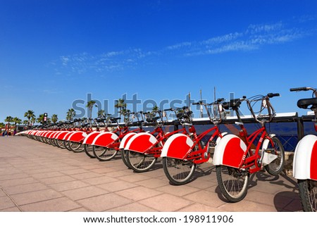 Bike Sharing in Barcelona Spain / Long row of red and white bicycles (public bikes) near the harbor in Ronda Litoral, Barcelona - Spain