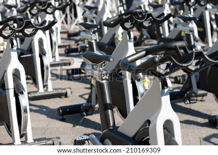 Spinning bikes / Large group of aluminum spinning bikes outdoors